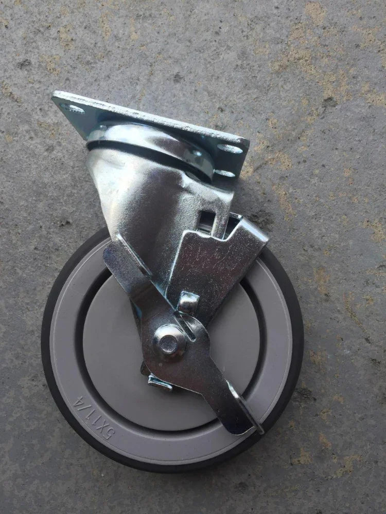 Gray caster wheel with a brake and shiny metal hardware.